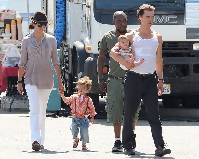 Matthew McConaughey, white tank top, black dress pants, Camila Alves, white pants, brown fedora, beige shirt, bracelets